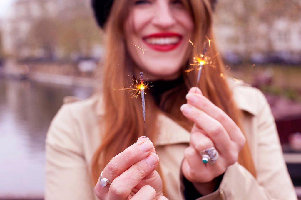 Portrait of woman holding mini sparklers