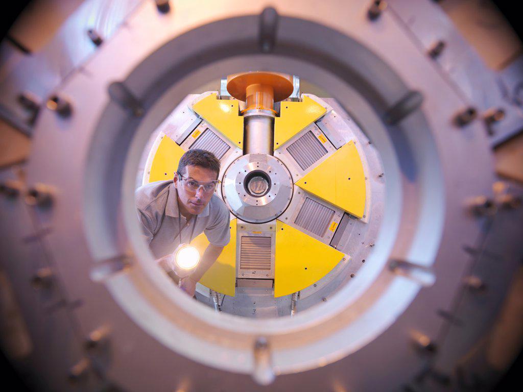 Scientist inspects particle accelerator