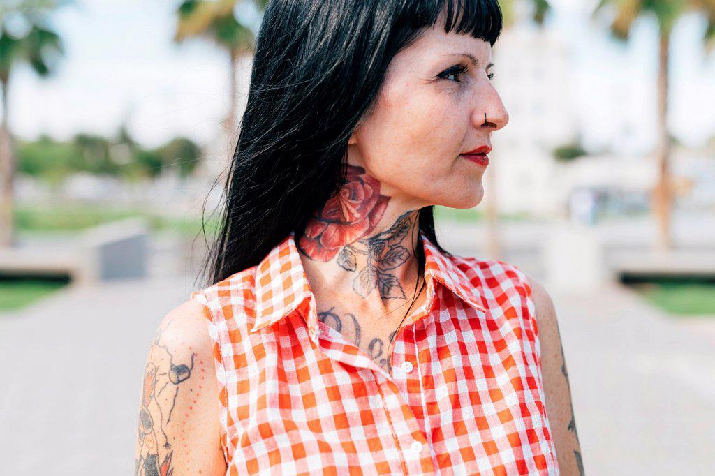 Mature female hipster with tattooed neck, close up