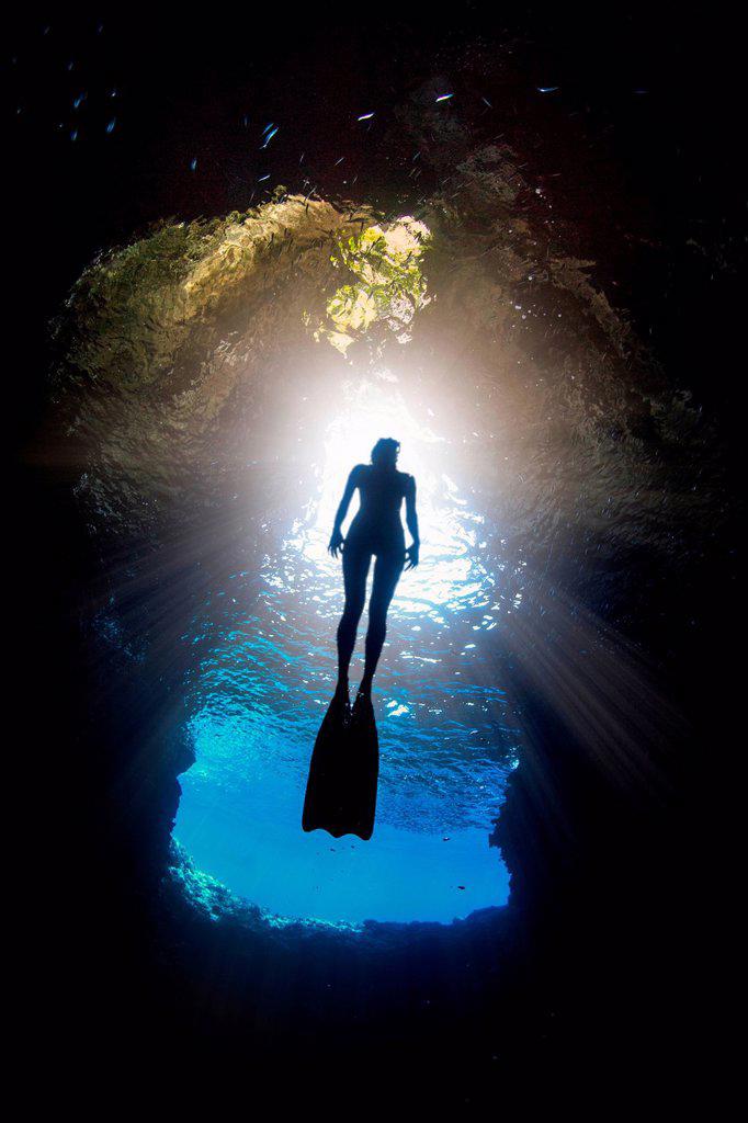 Woman free-diving, low angle view, Swallow Cave, Vavau, Tonga, Fiji