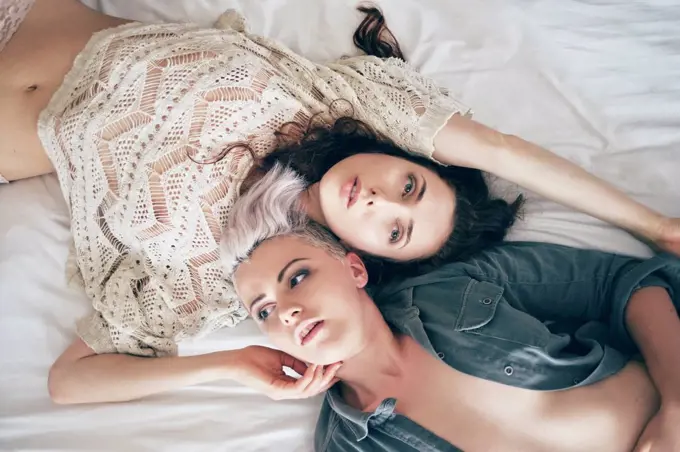Portrait of young women lying on bed