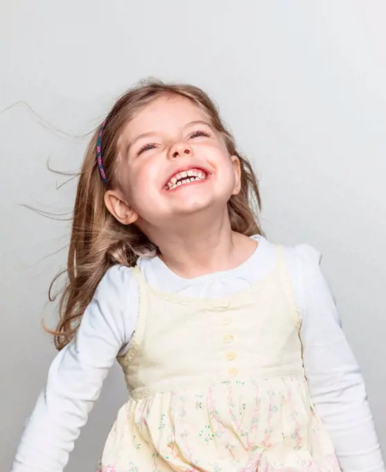 Studio portrait of cute girl laughing