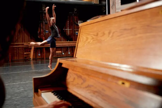 Ballet dancer in position, piano in foreground