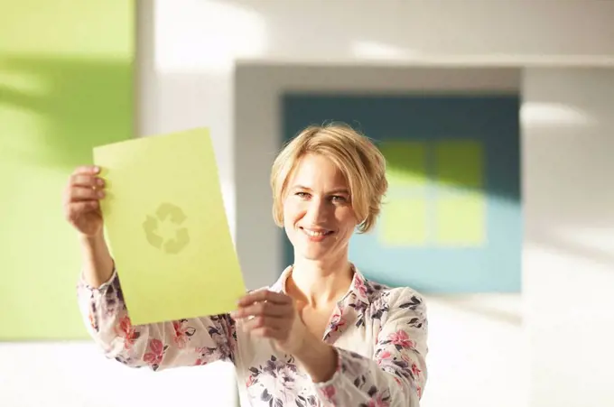 Woman looking at green sheet with logo