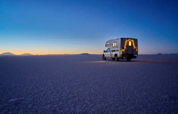 Recreational vehicle, travelling at dusk, across salt flats, Salar de Uyuni, Uyuni, Oruro, Bolivia, South America