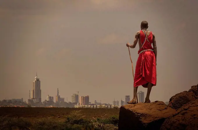 Masai man with traditional dress watching Nairobi's skyline, Nairobi, Nairobi Area, Kenya