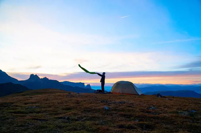 Hiker preparing to camp at sunset, Canazei, Trentino-Alto Adige, Italy