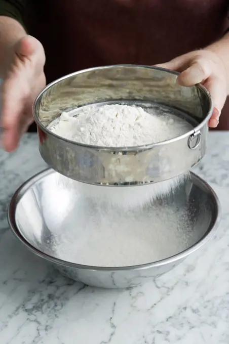 Chef sifting flour in bowl