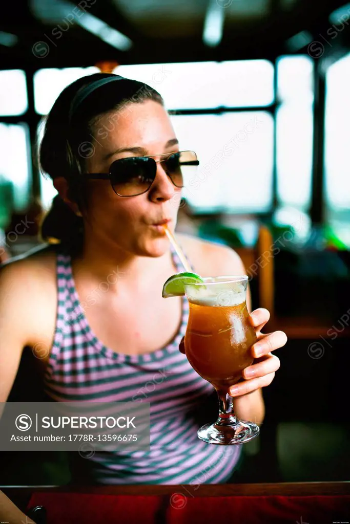 A woman drinks an exotic cocktail