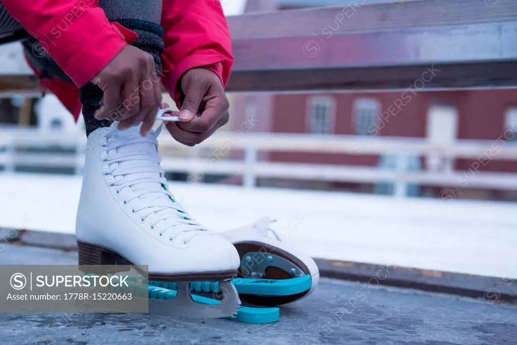 Low section photograph of African American woman putting on ice skate