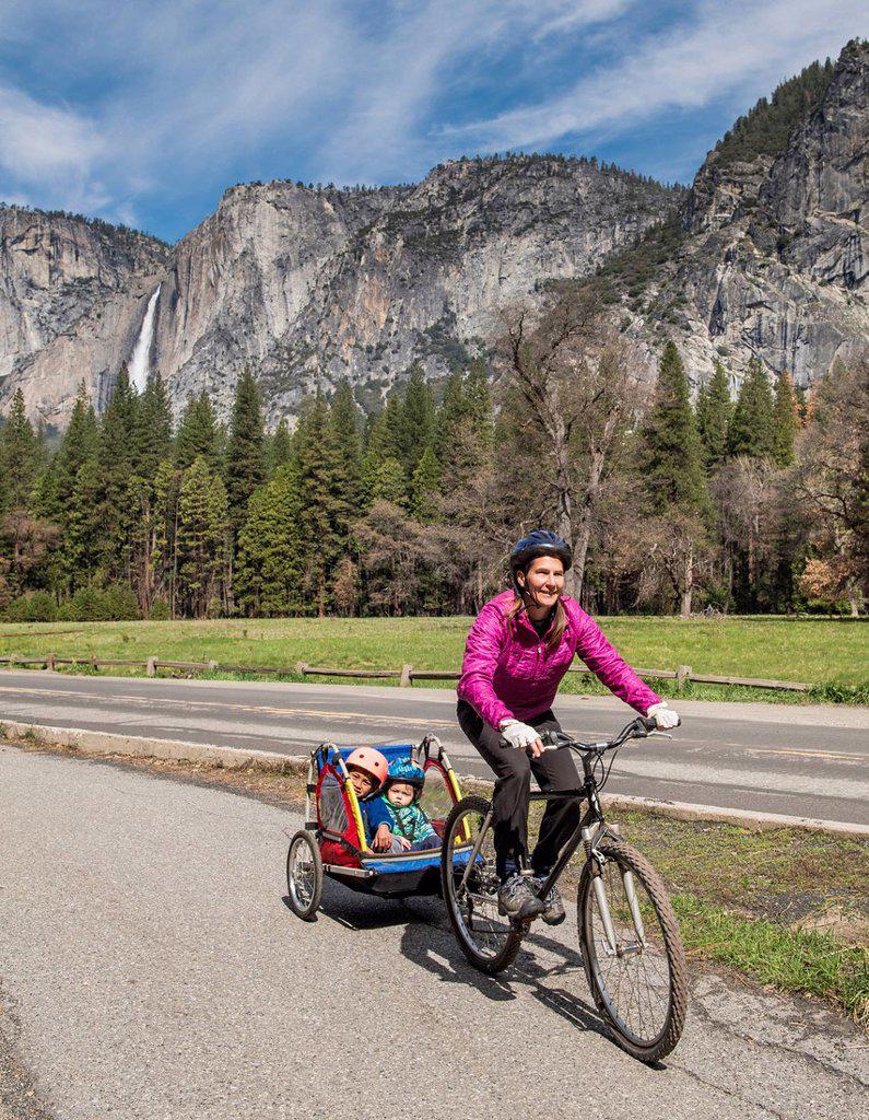 Woman bike riding with kids, Yosemite in backgound