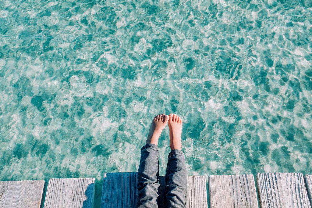 Close up of the kids feet over turquoise waters, Mallorca, Balearic Islands, Spain