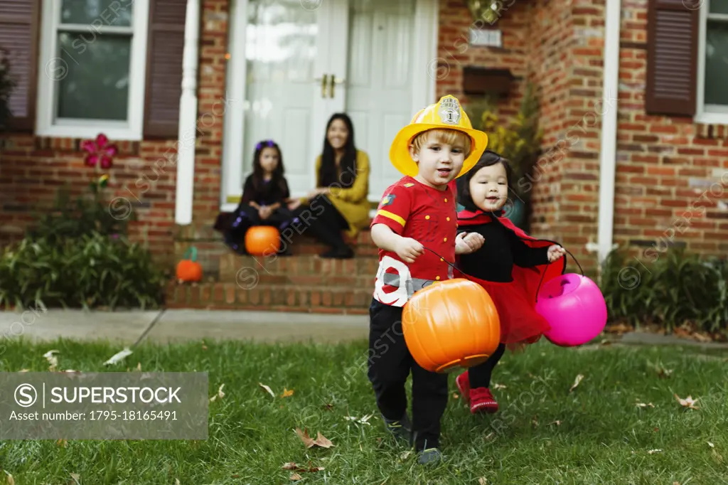 Boy dressed as fireman with trick or treat bucket