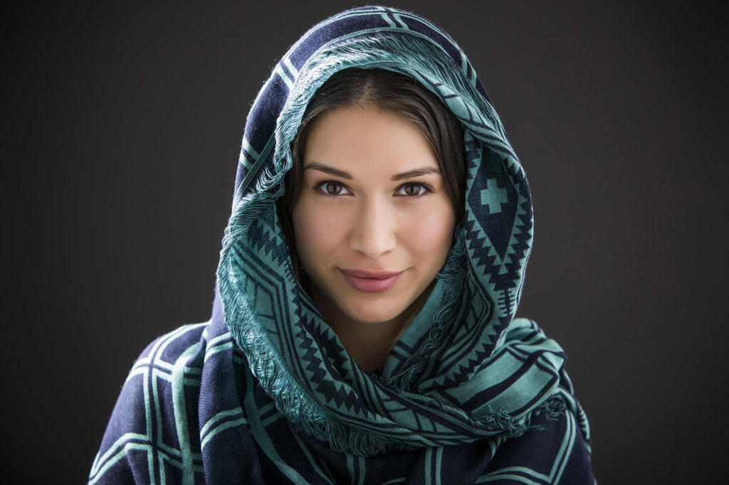 Studio portrait of smiling woman with shawl on head