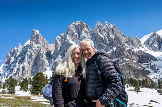 Smiling couple by mountain in Dolomites, Italy