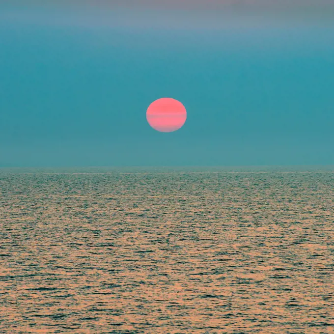 Red setting sun over ocean