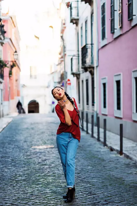 Portugal, Lisbon, Young woman blowing kiss in old town