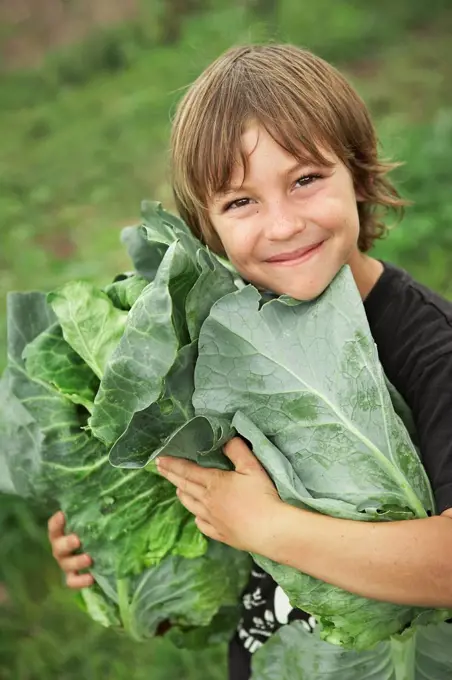 Portrait of boy 6_7 holding lettuces