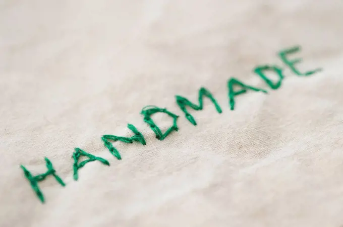 Close up of embroidered handmade word, studio shot