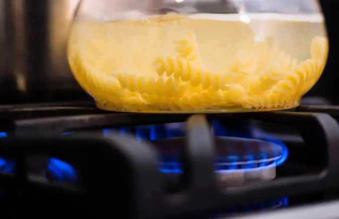 Close_up of pasta boiling on gas burner