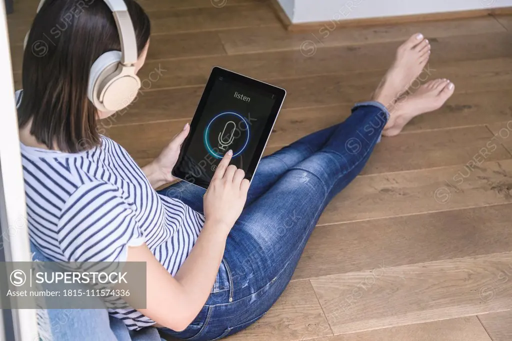 Young woman with tablet awith smart home control functions and headphones