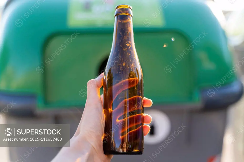 Close-up of man holding bottle for recycling