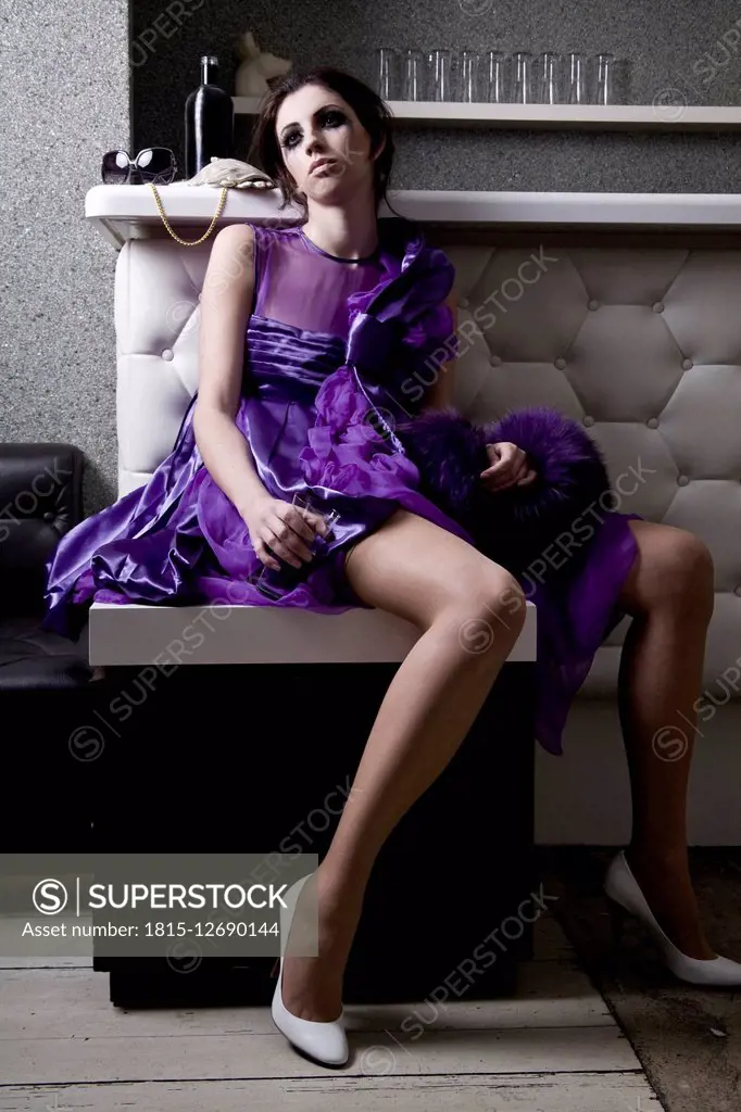 Disappointed young woman in purple evening dress