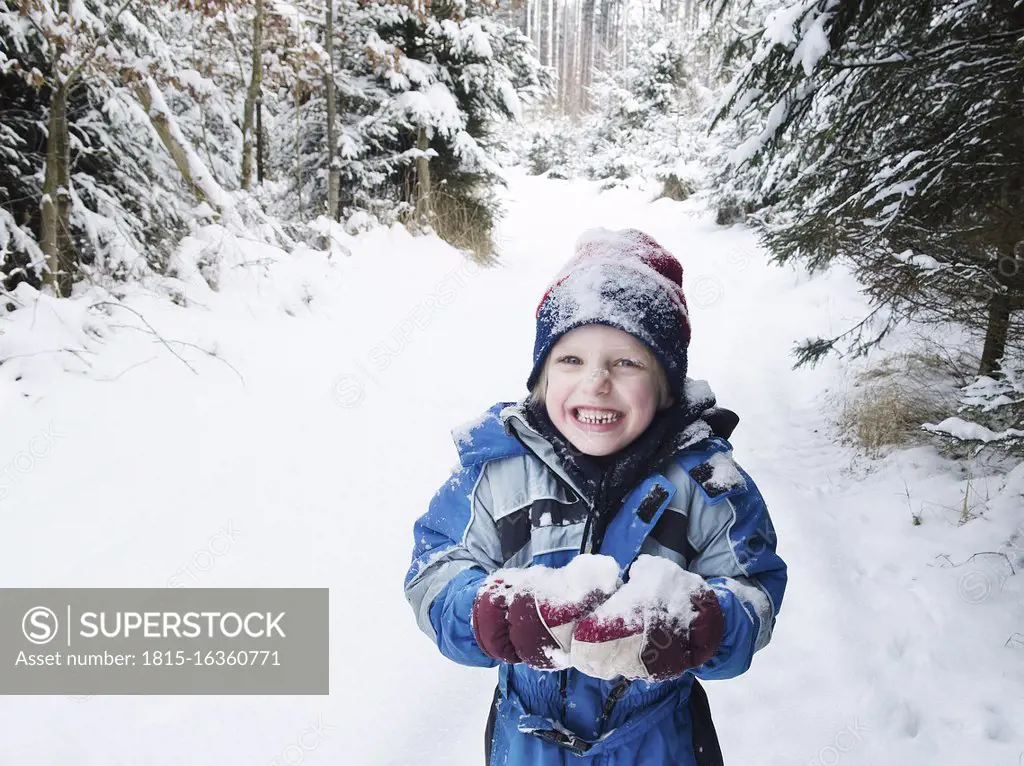 Austria, Boy playing with snow in forest