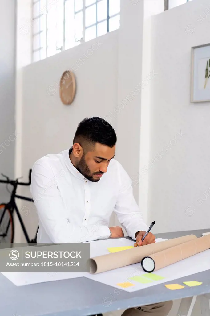 Male entrepreneur planning strategy while sitting at desk in office