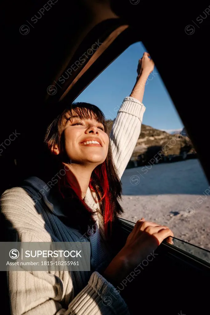 Happy young woman travelling in car