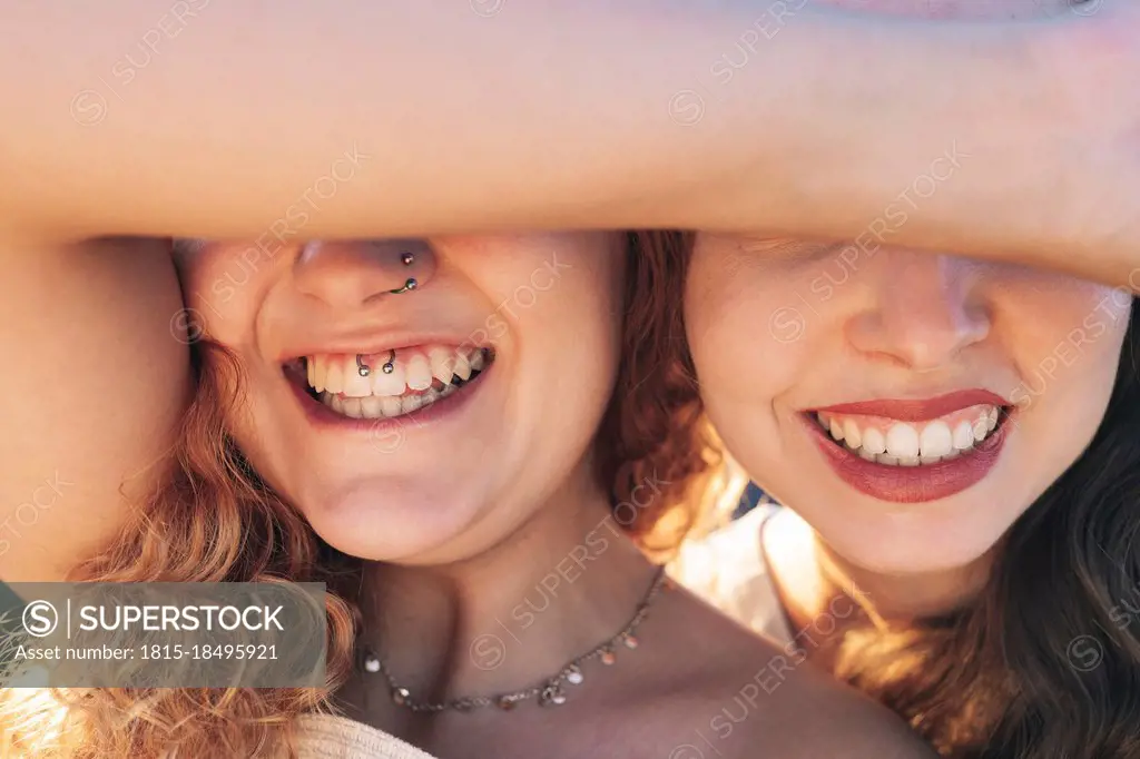 Happy young female friends covering eyes
