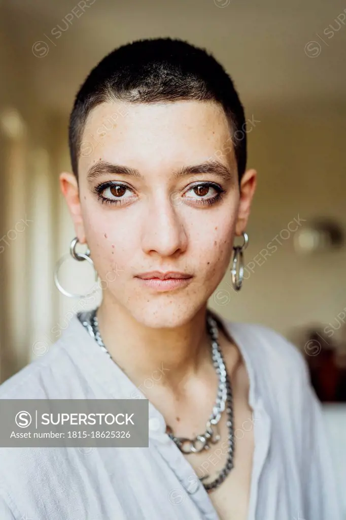 Young woman with short hair wearing jewelry at home