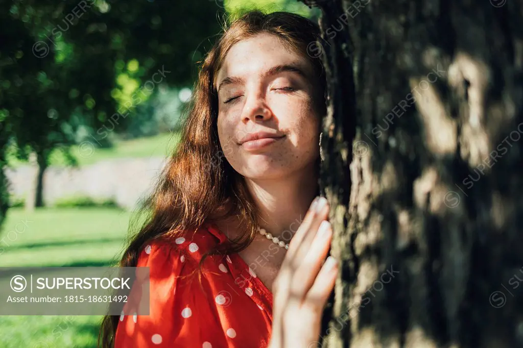 Woman hugging tree at park