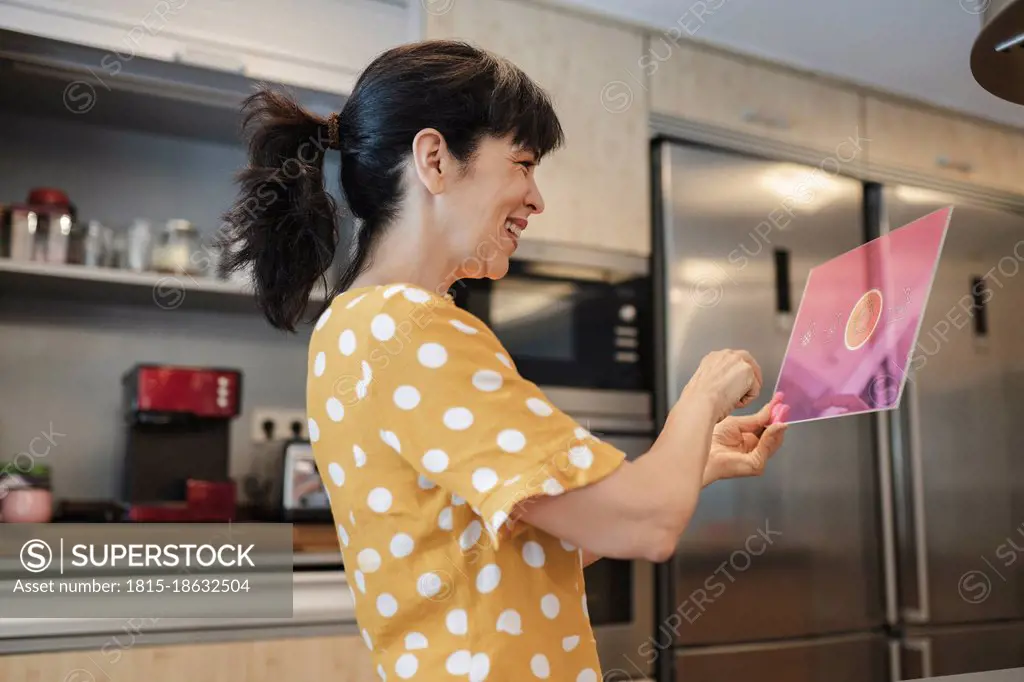Happy woman using digital tablet in kitchen at home