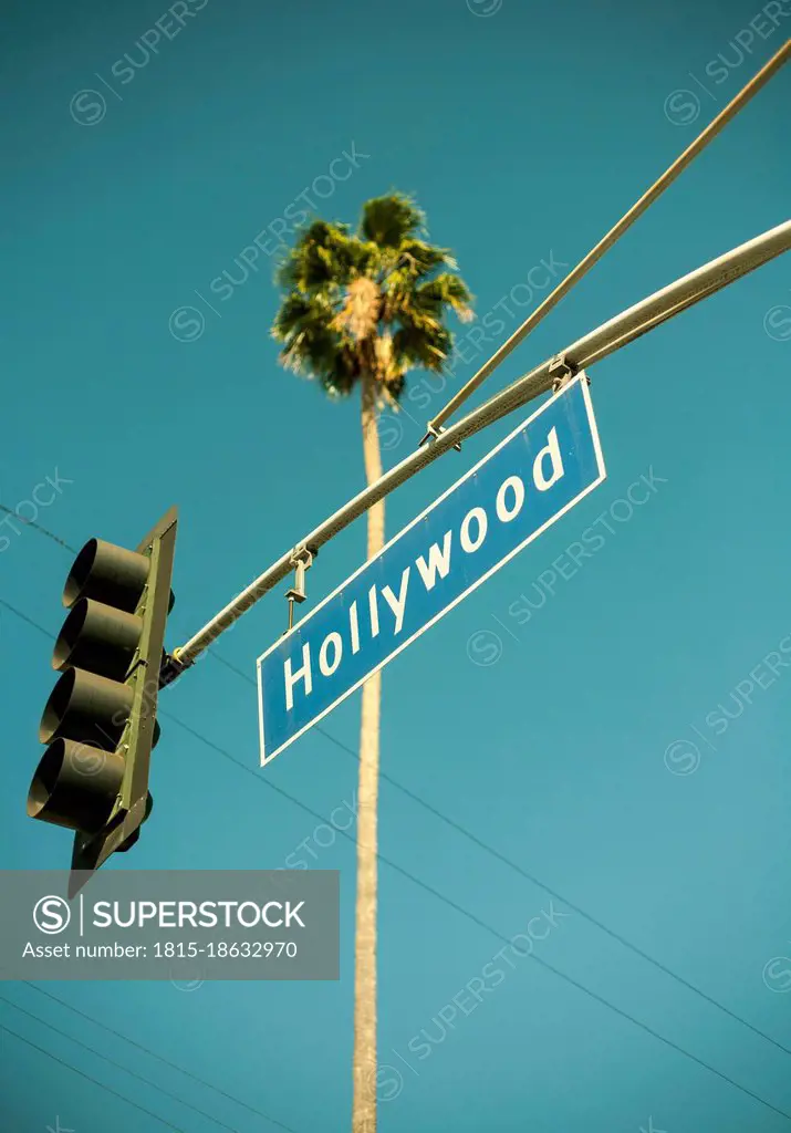 USA, California, City of Los Angeles, Stoplight with Hollywood sign hanging against clear turquoise sky