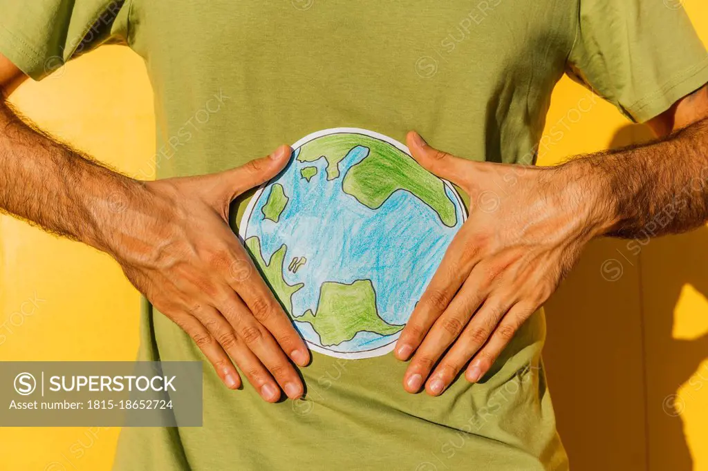 Man holding planet earth drawing during sunny day