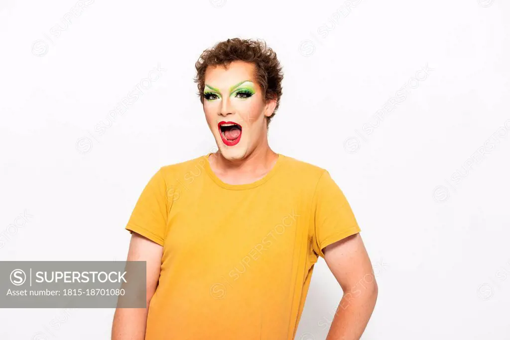 Man with make-up on face shouting against white background