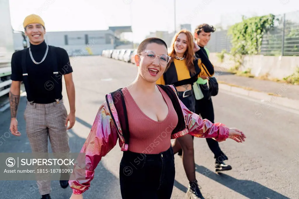 Happy woman walking with friends in background on road