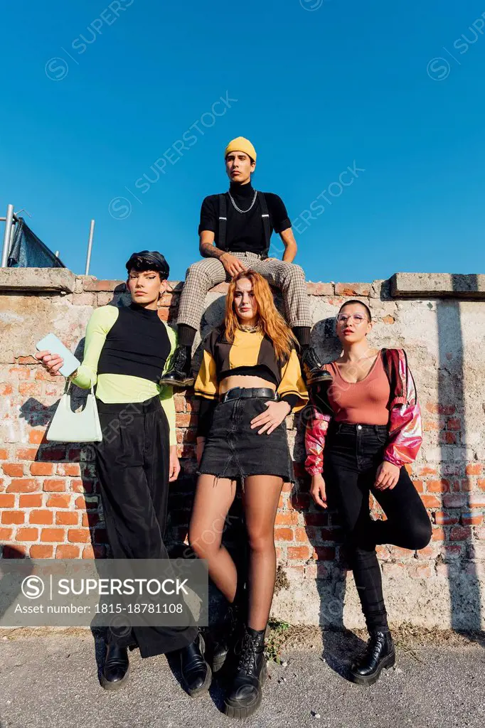 Man sitting with friends on brick wall