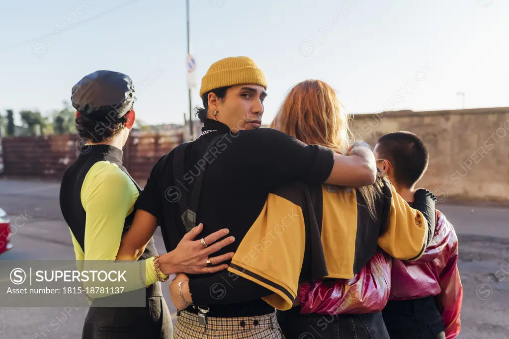 Man with arm around friends on road