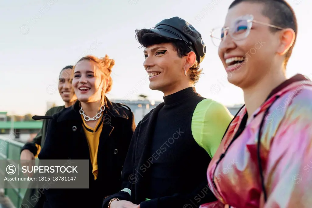 Smiling gay man with friends at sunset