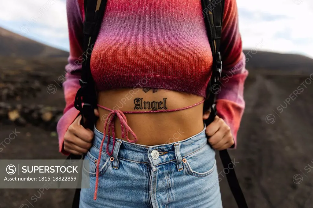 Woman with ANGEL word tattoo on stomach