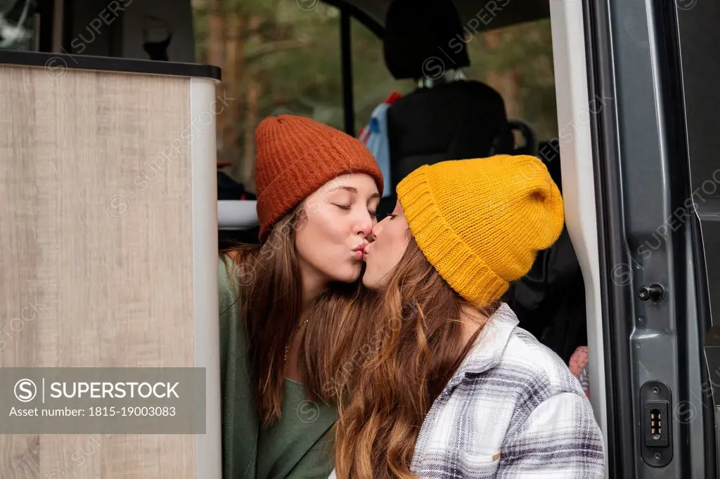 Affectionate lesbian couple kissing in van