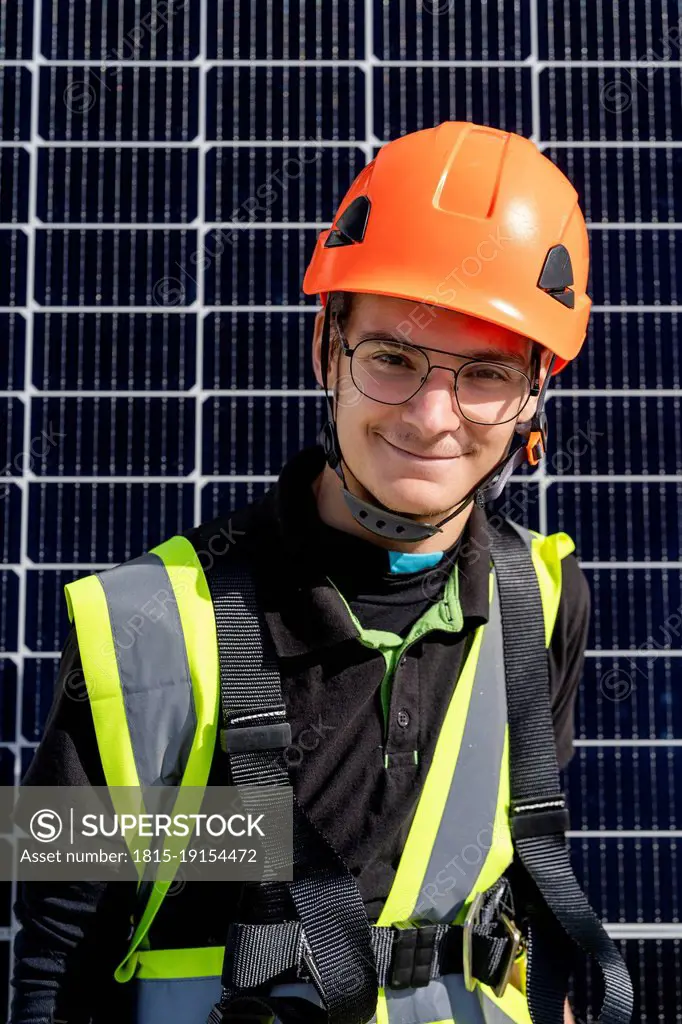 Smiling technician with helmet on sunny day