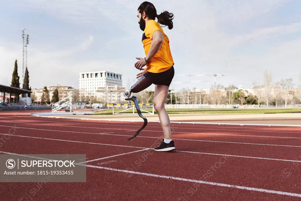 Athlete with prosthetic leg warming up on running track