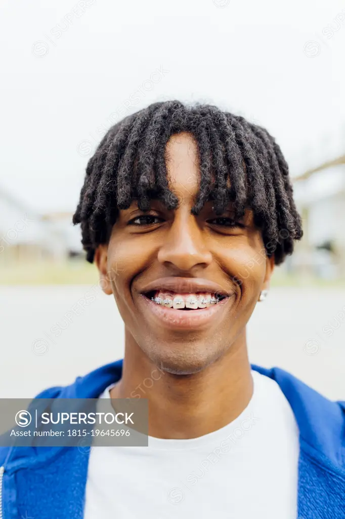 Happy young man with dental braces