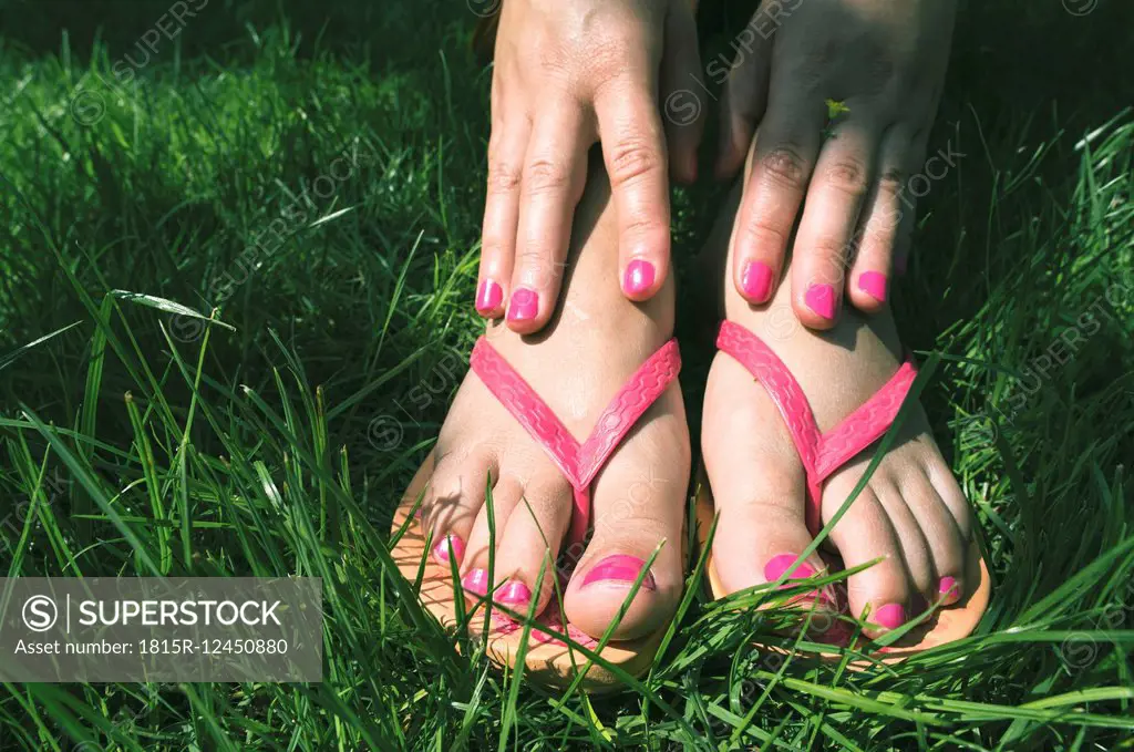 Woman's hands and feet on a meadow