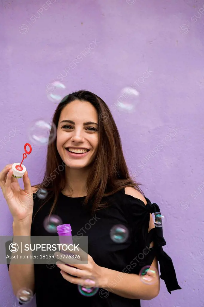 Portrait of smiling young woman with bubble ring