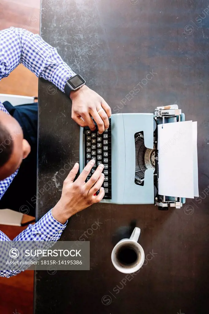 Young man at desk using typewriter