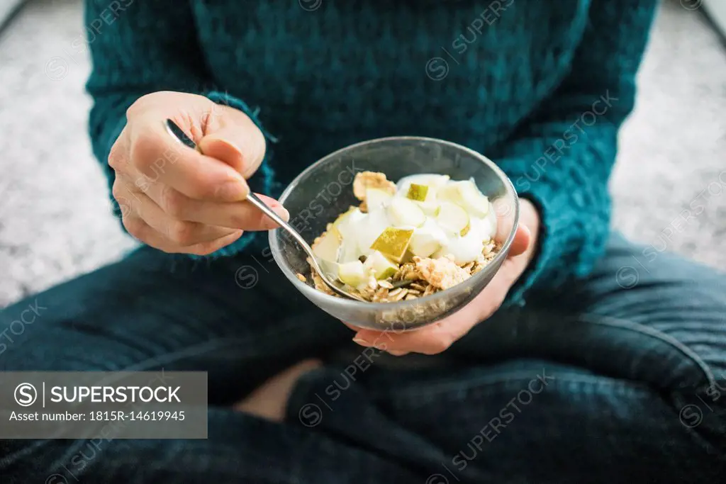 Close-up of woman eating fruit muesli